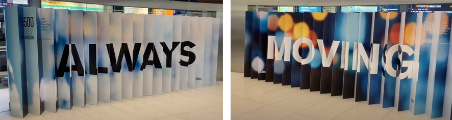 Indoor display sign with the text 'ALWAYS MOVING' in large, bold letters